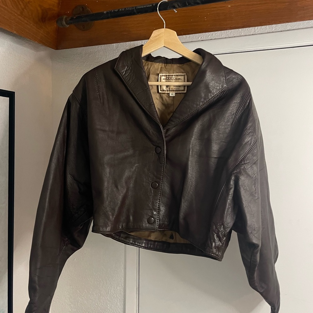 Women as brown leather jacket. Size M. Cropped. Front button up w collar.